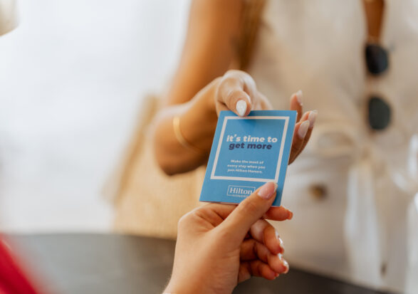 A person hands a blue card reading 